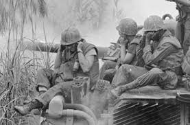 Soldiers huddled together over a machine.