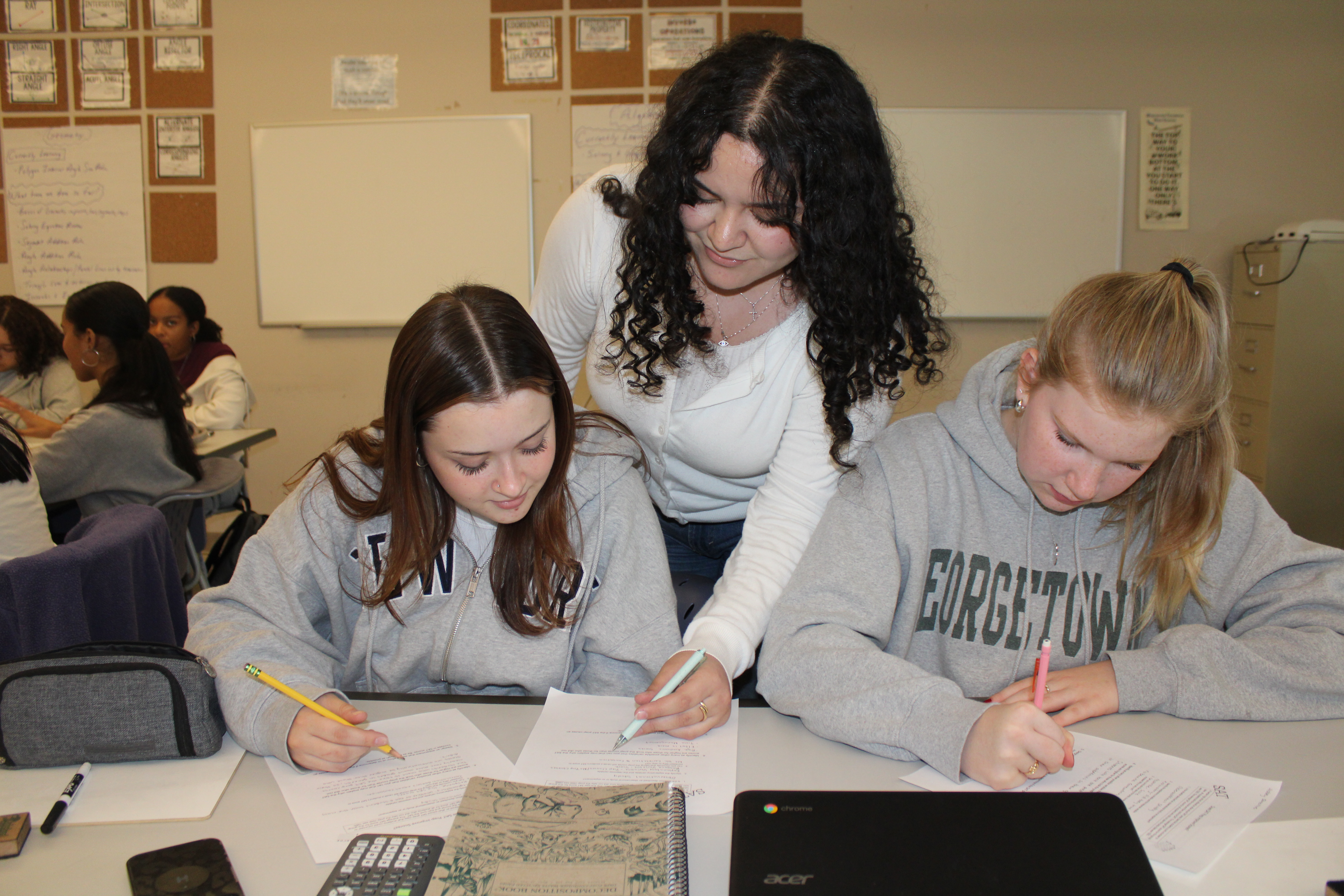 Three girls collaborating on a math project.