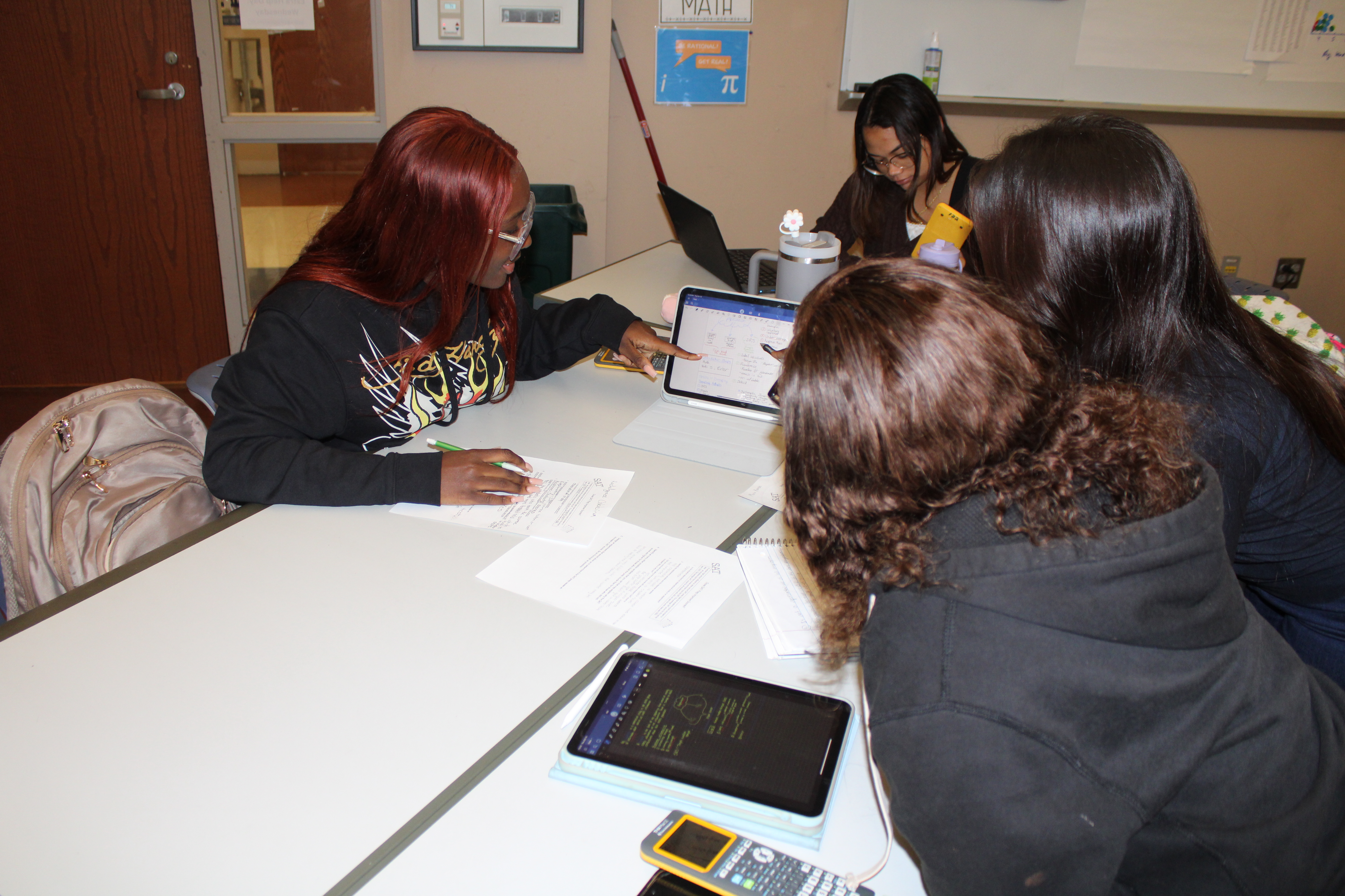 Three girls working together on ipads in math class.