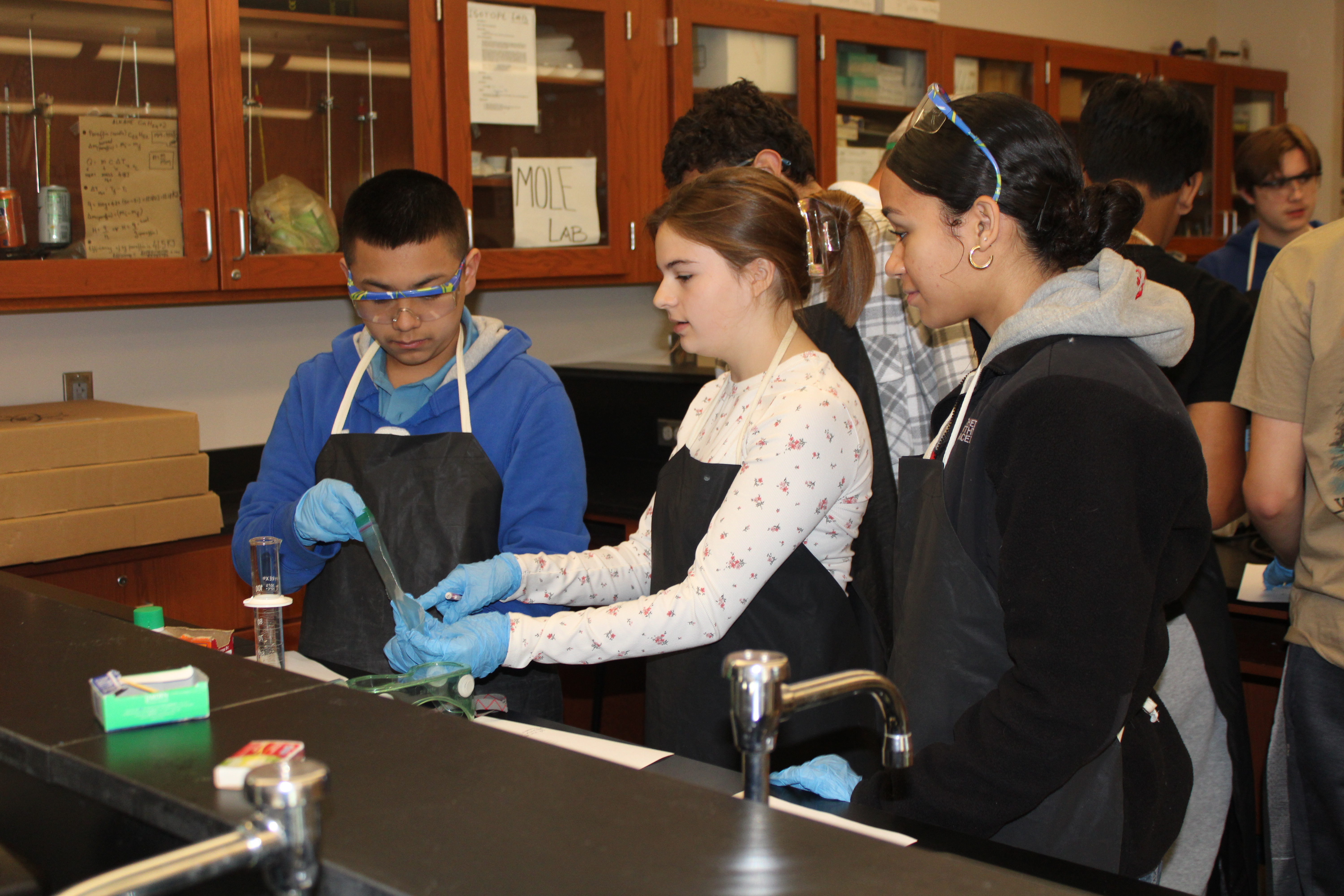 Three students collaborating on science lab.