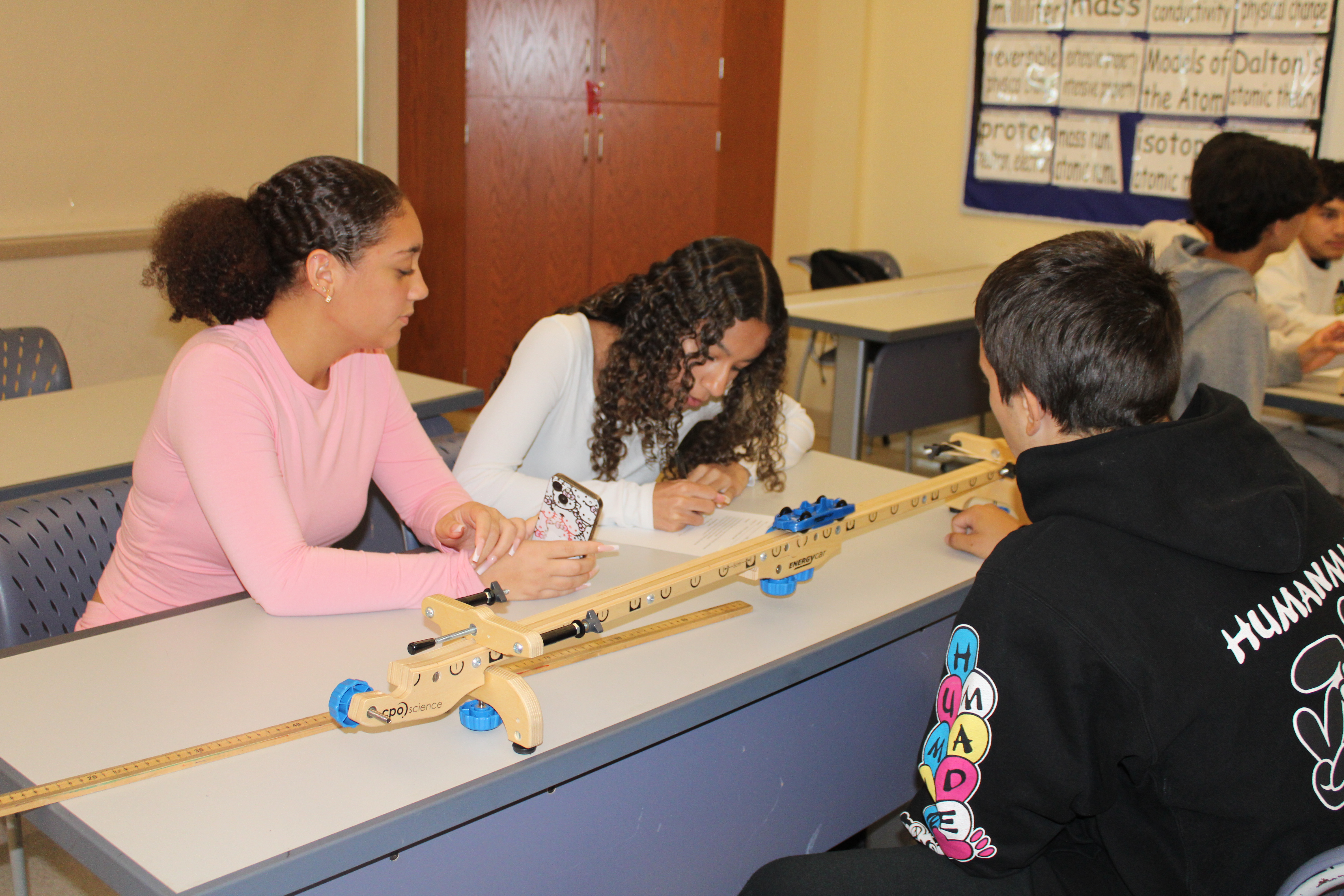 Three students recording data from their science lab.