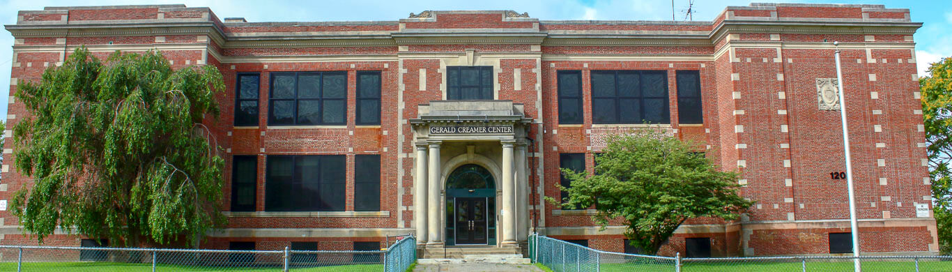 Gerald Creamer Day Old style tall school building with columns at the entrance 