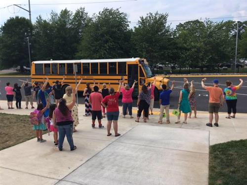 Kids in Front of School Bus Waving