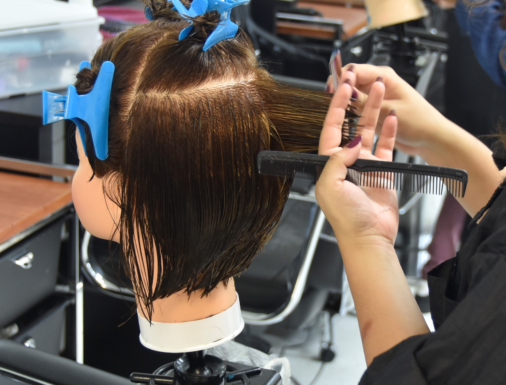 Student cutting hair on a manequin