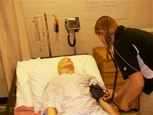 student checking the pressure to an medical aid doll