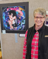 art's teacher next to a painting at an event