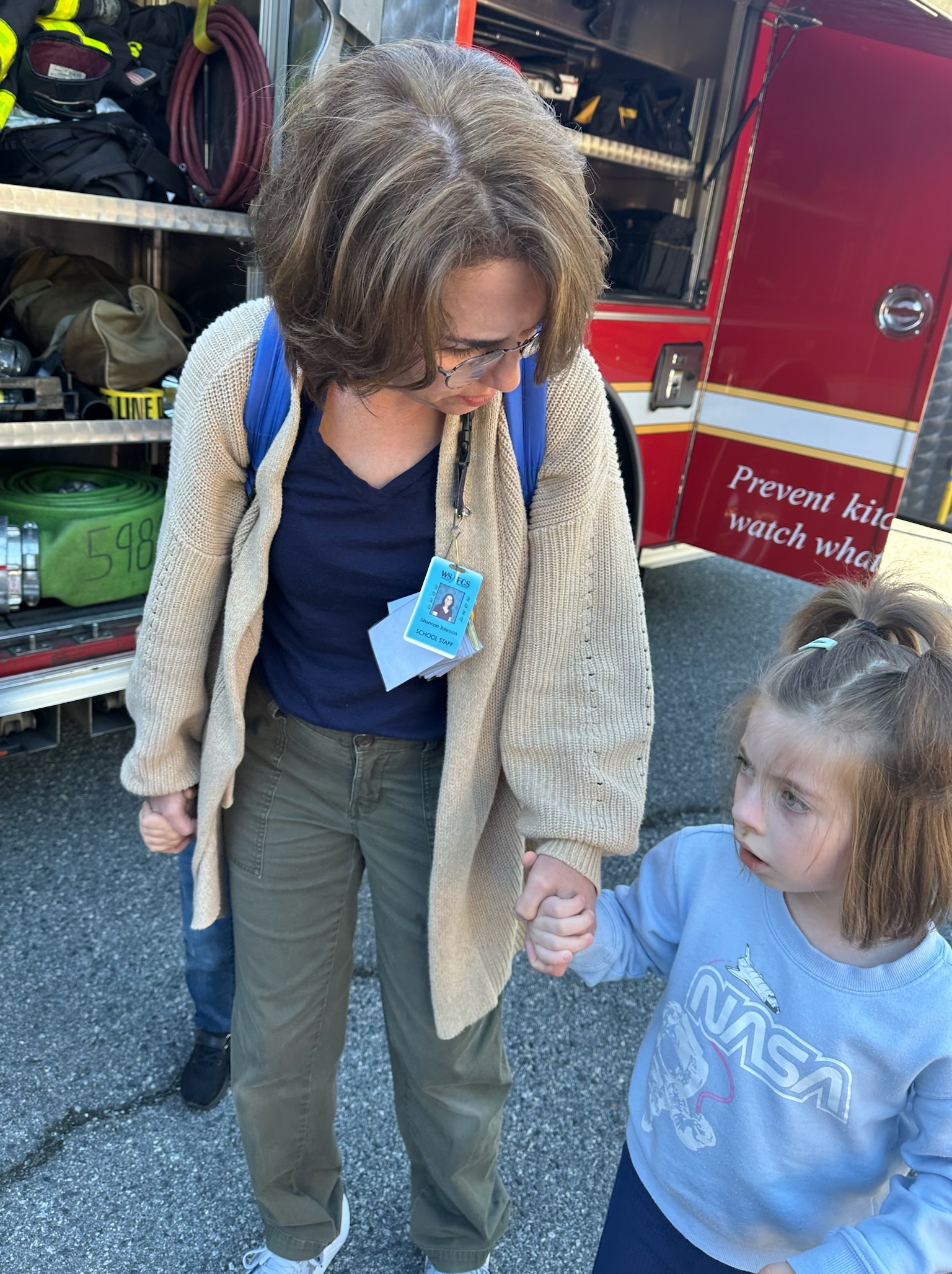 student and teacher assistant looking at fire truck