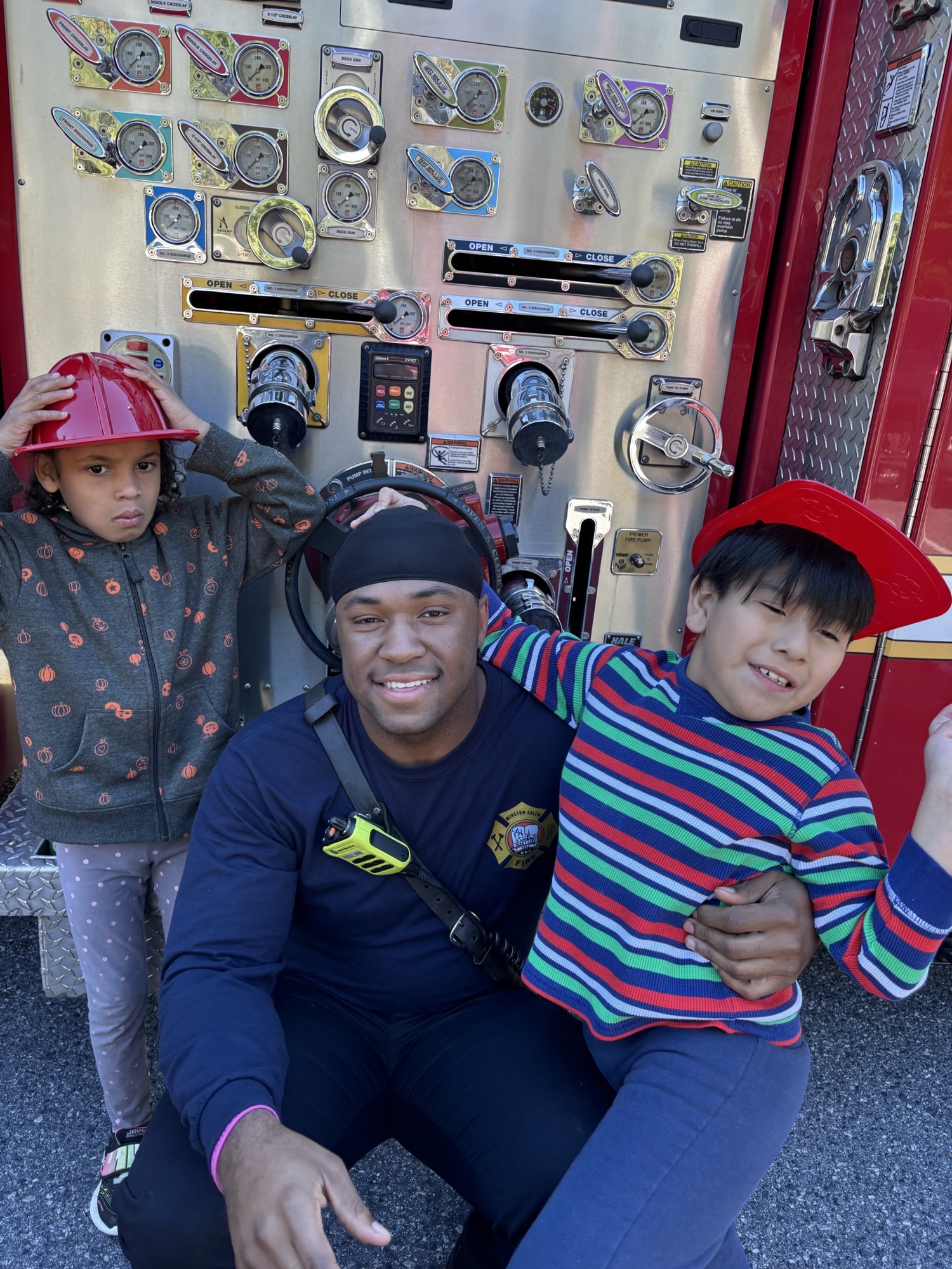 students with firefighter at firetruck