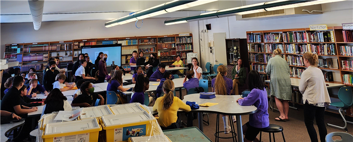 classroom full of students and teachers in the middle of a presentation