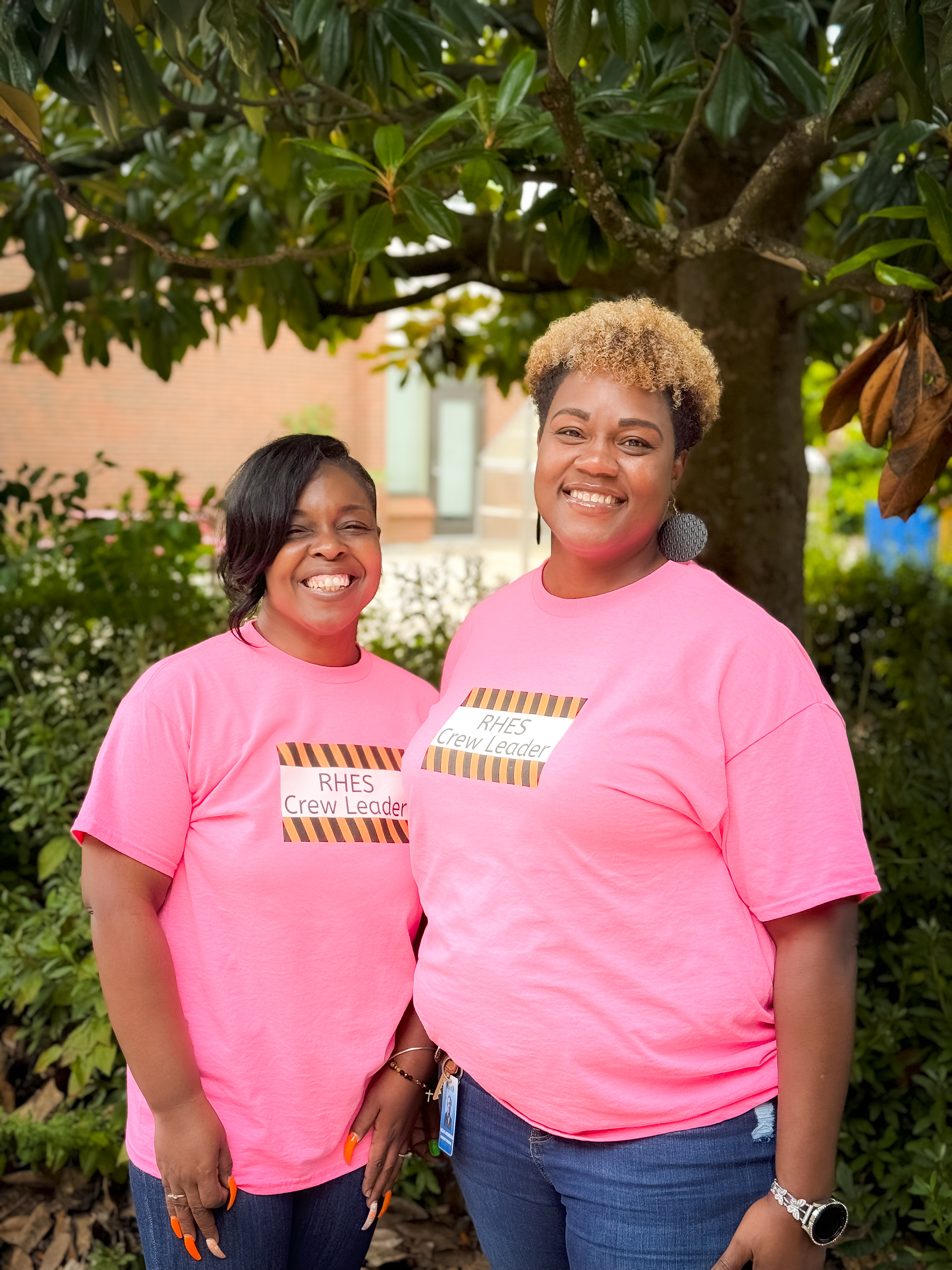 The RHES principal and assistant principal standing outside in matching pink shirts