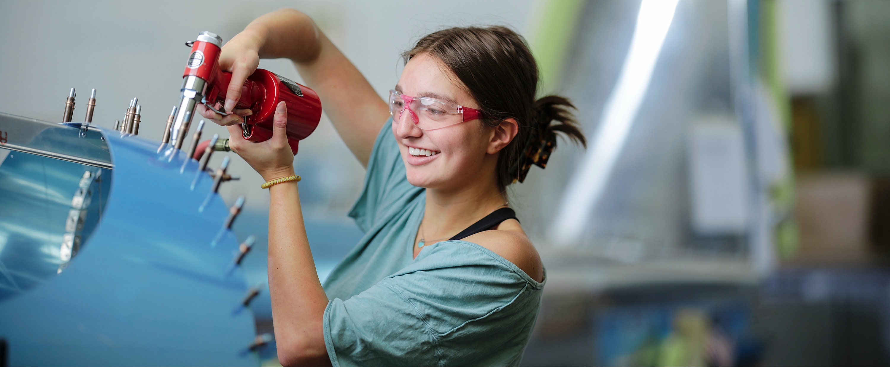 female student working on airplane in aviation class