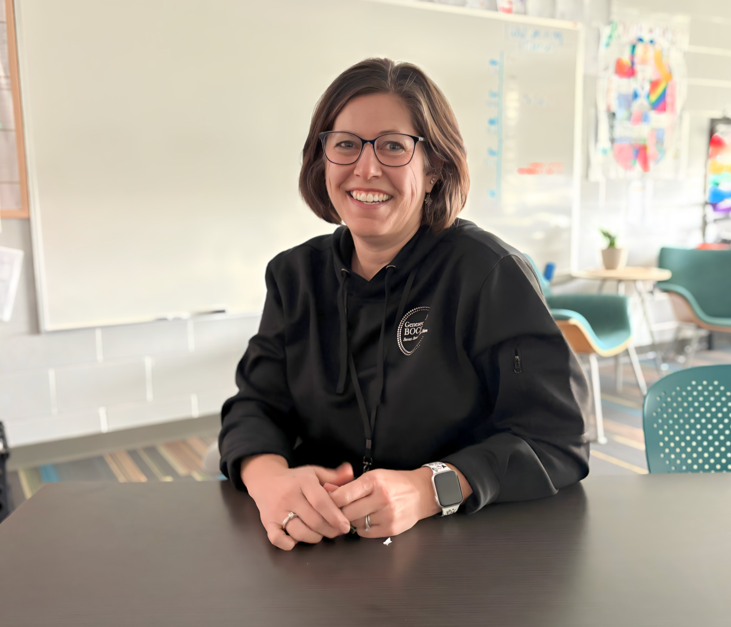 Catherine Bennett sitting in a classroom smiling. 