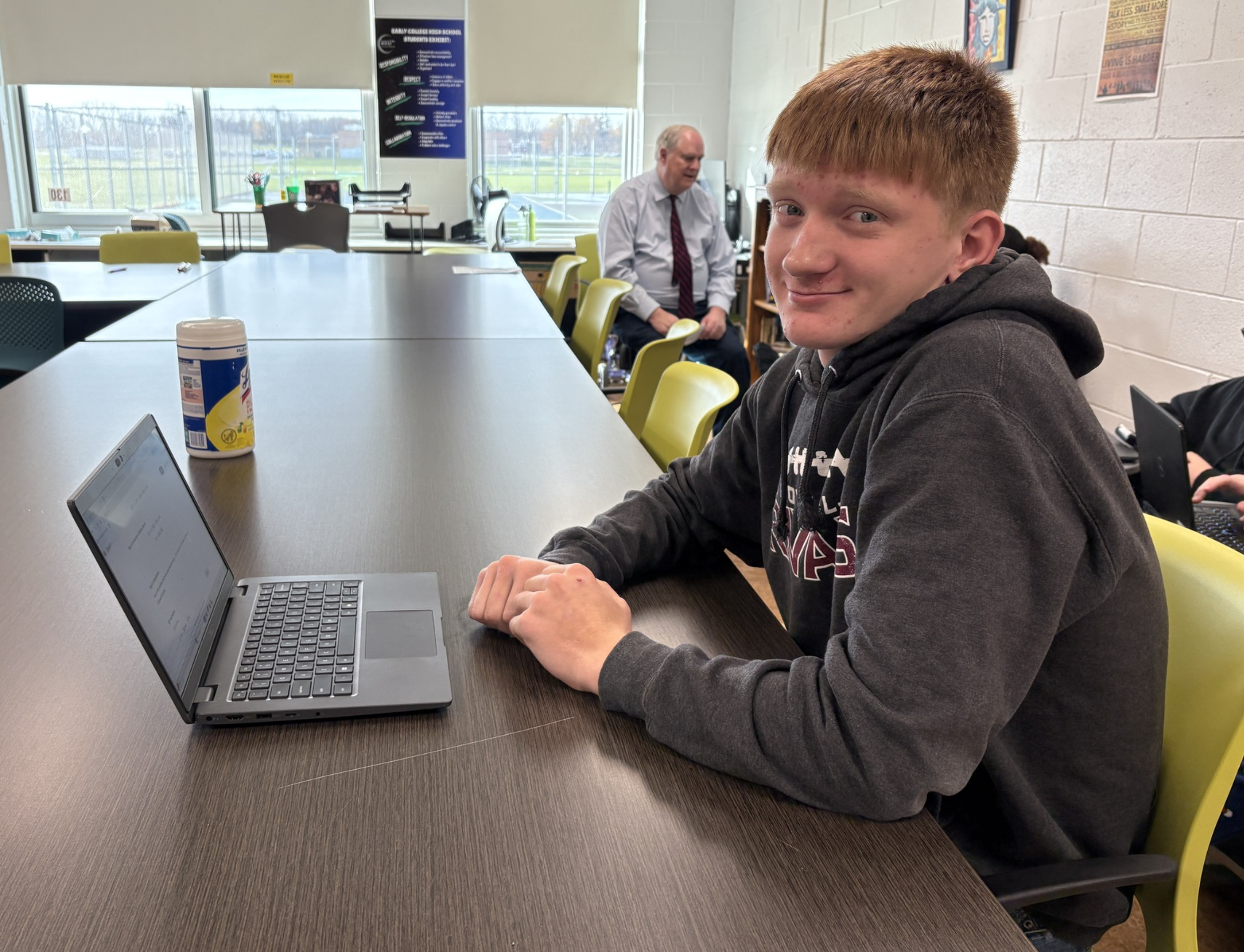 Student sitting at his desk on his laptop.