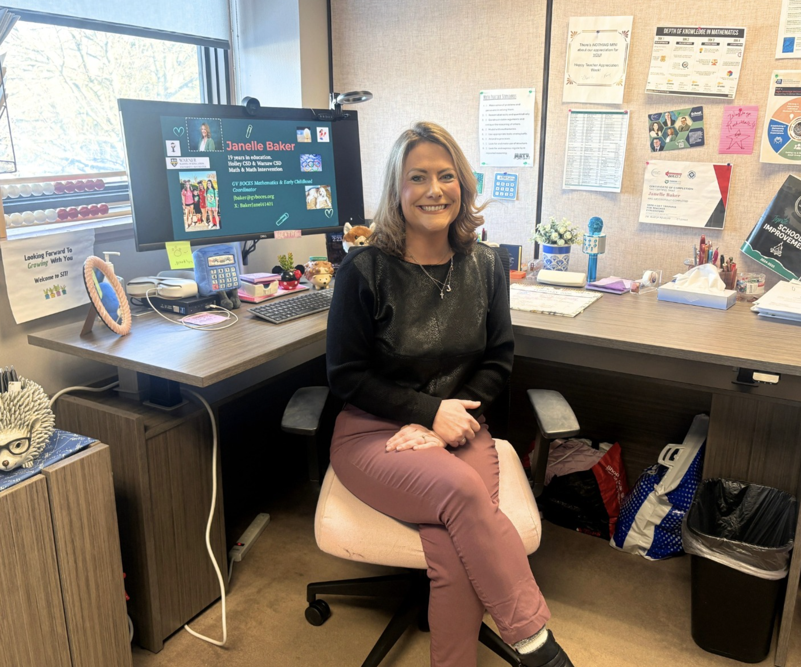 Janelle sitting in front of her desk and computer.