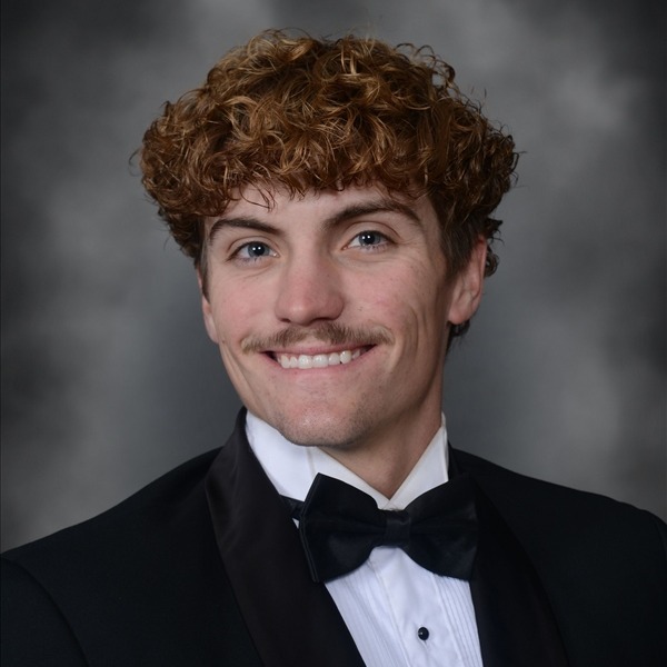 Senior Portrait of Trevor Cochran. He is wearing a white shirt with a black jacket and a black bow tie. The portrait is just a headshot, form the chest up.
