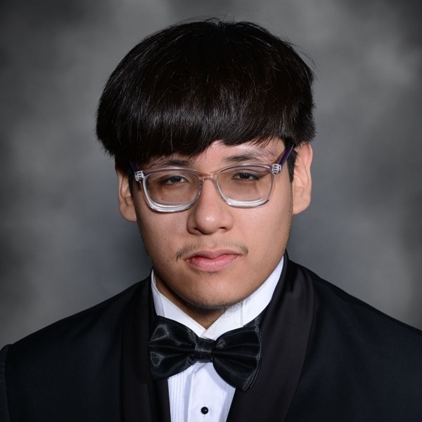 Senior Portrait of Adrian Greeley. He is wearing a white shirt with a black jacket and a black bow tie. He is wearing clear ad black framed glasses.The portrait is just a headshot, form the chest up.