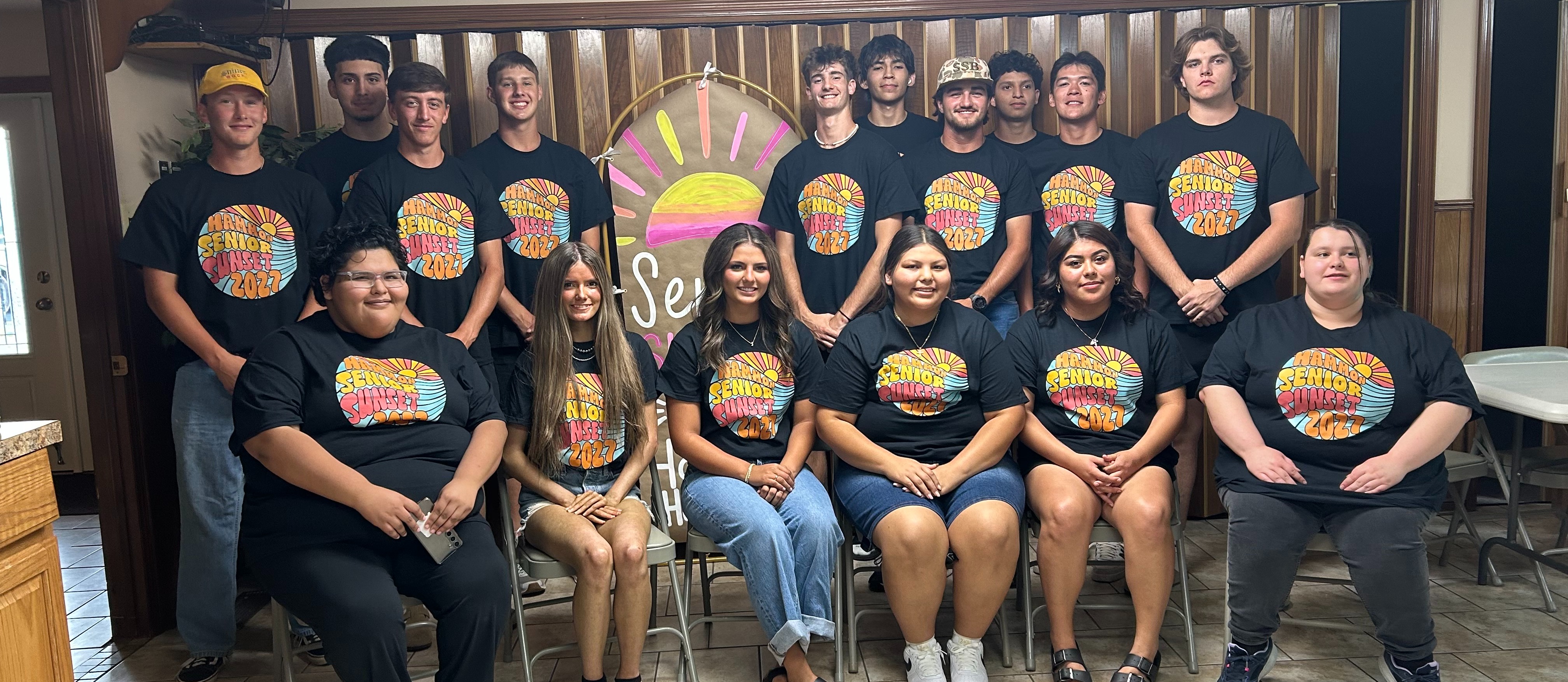 Senior Class at Senior Sunset.  Girls sitting in chairs and boys standing behind them.