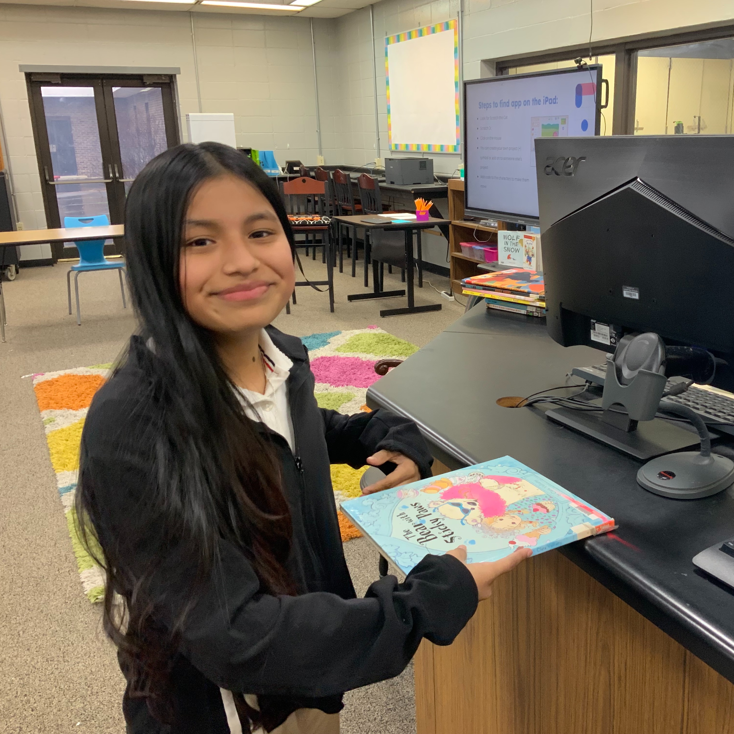 Girl checking out a library book at the circulation desk.
