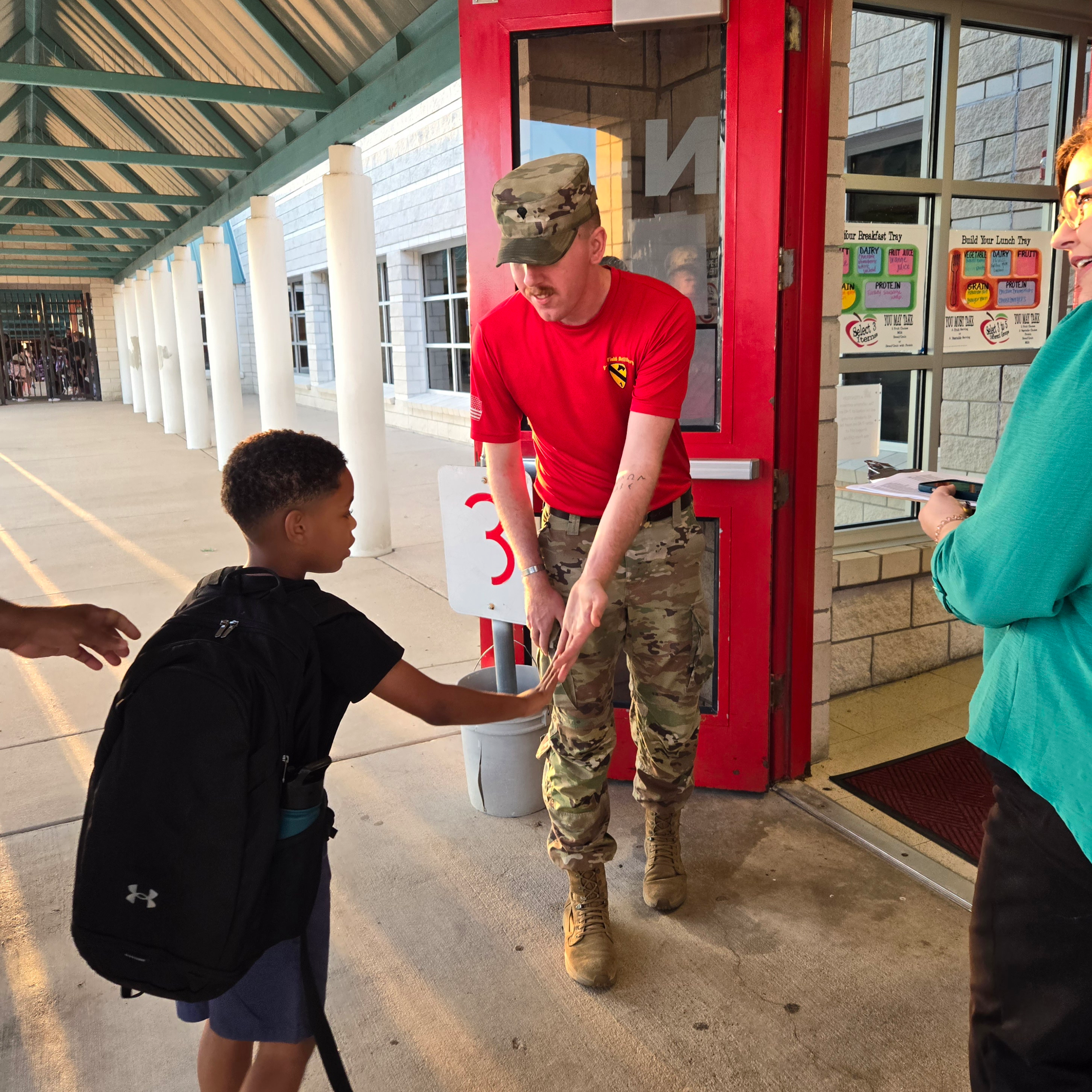 Soldier Welcomes Student to School