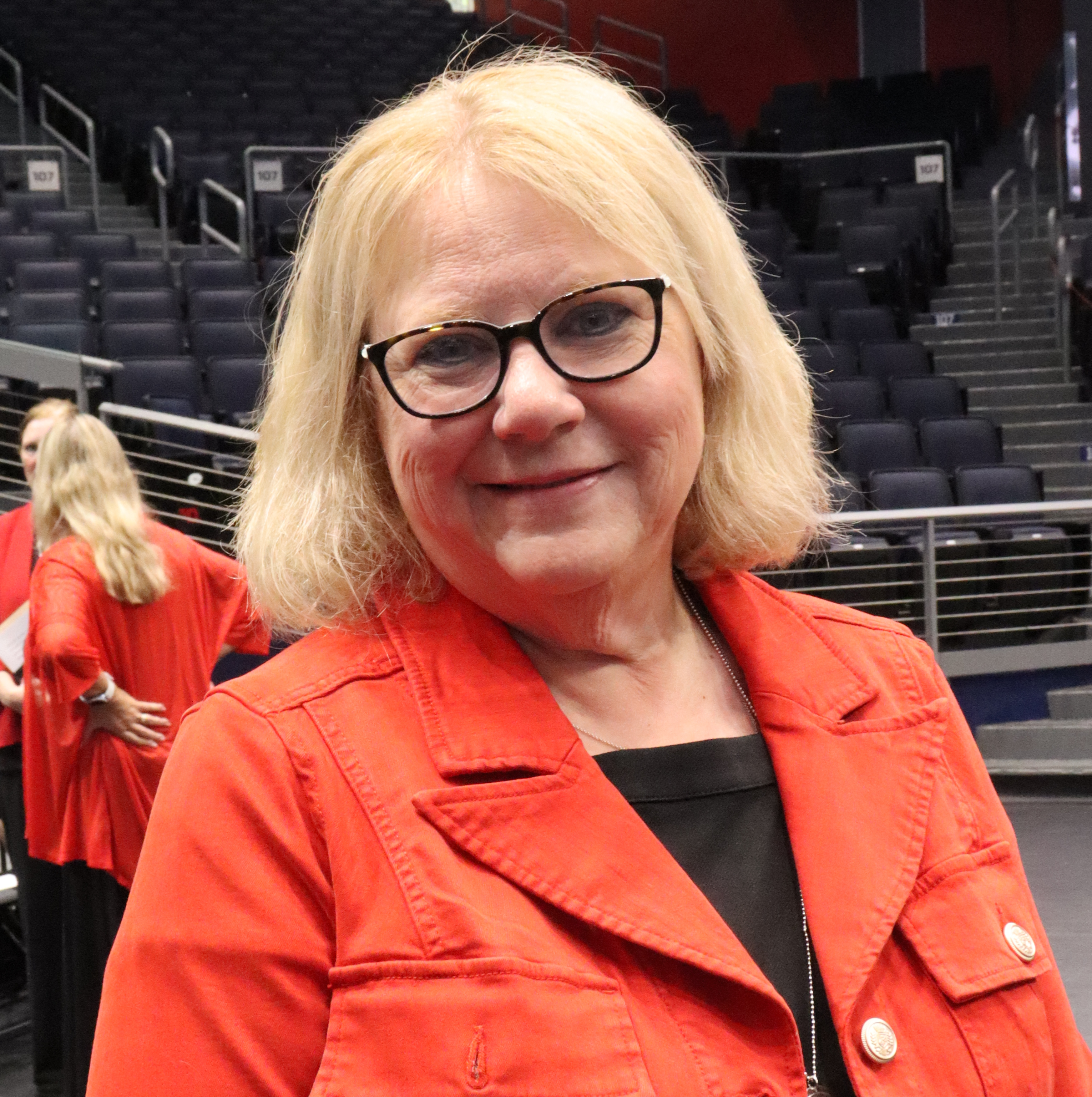 Woman smiling with blonde hair and a red jacket