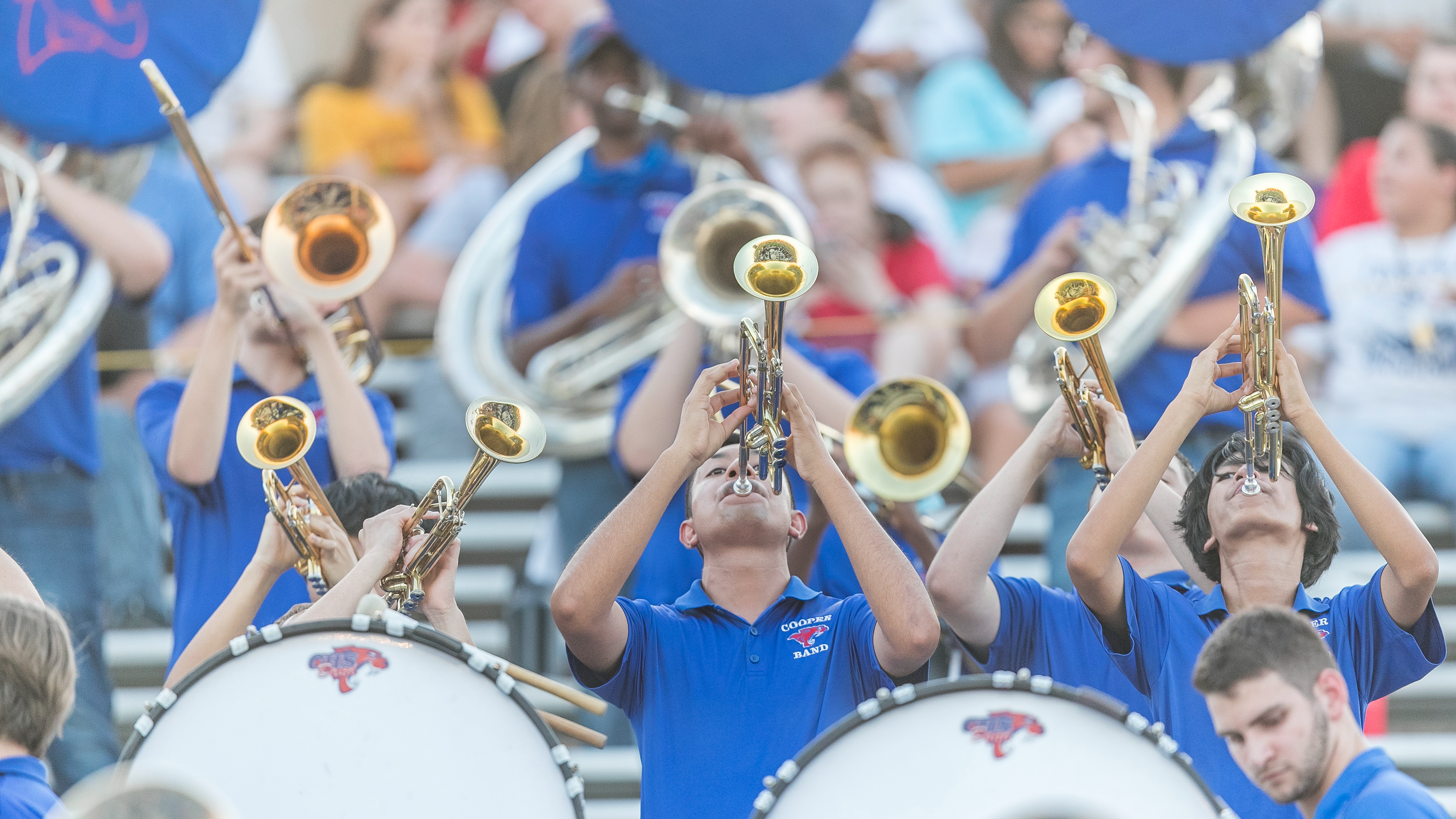 High School band students play their instruments at a football game