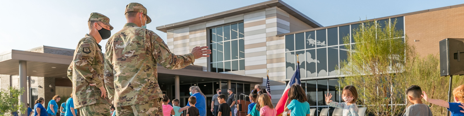A photo of servicemen waving to Dyess ES students