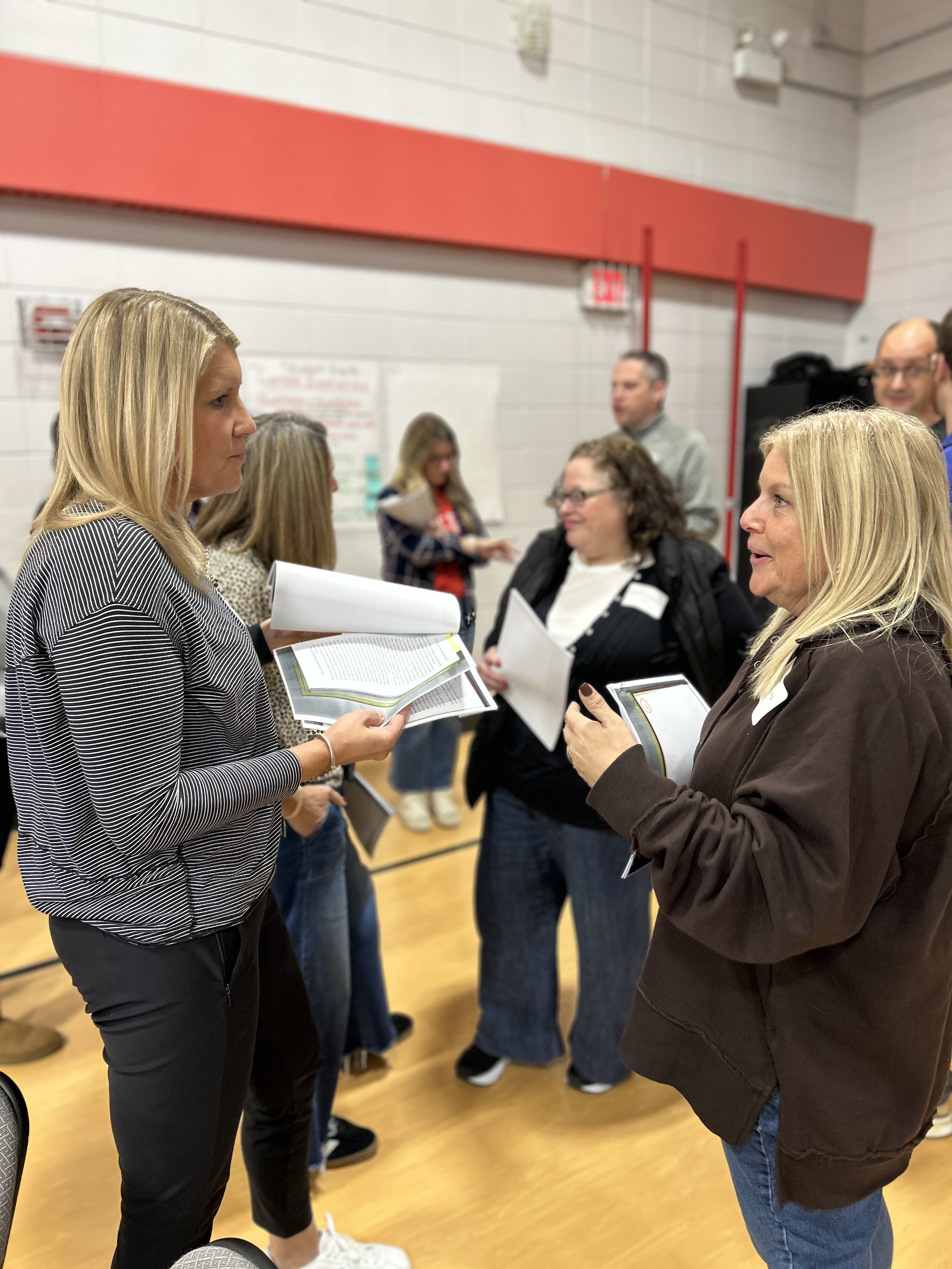 3 teachers standing together and talking to each other.