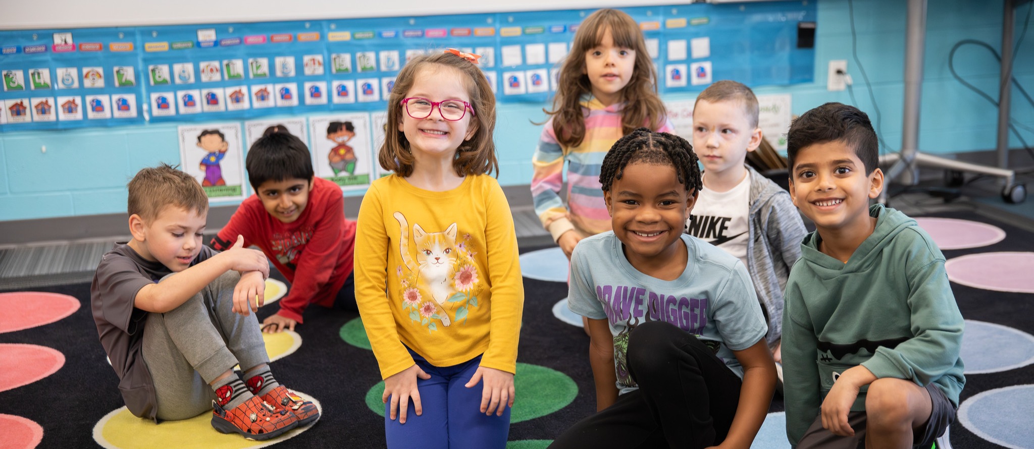 Picture of students kneeling and smiling
