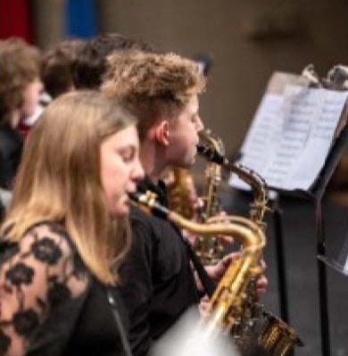 young lady and boy playing saxophones in a concert band
