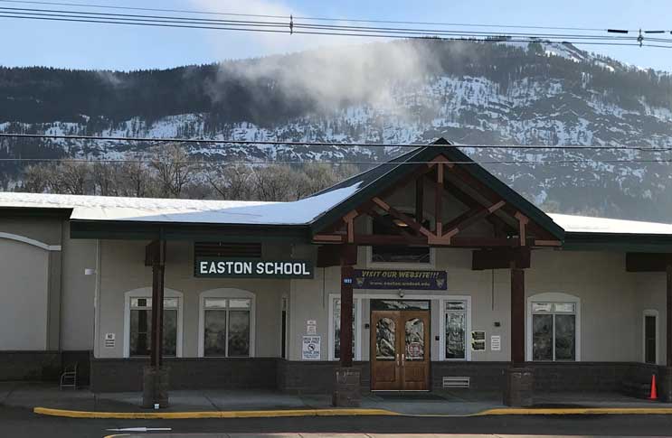 exterior of Easton School with mountain with snow in the distance