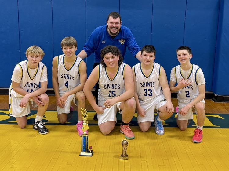 Boys JV basketball players with trophy