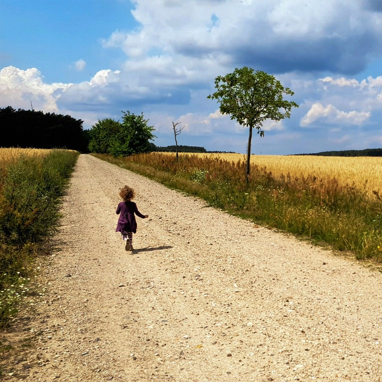 child running along a dirt road
