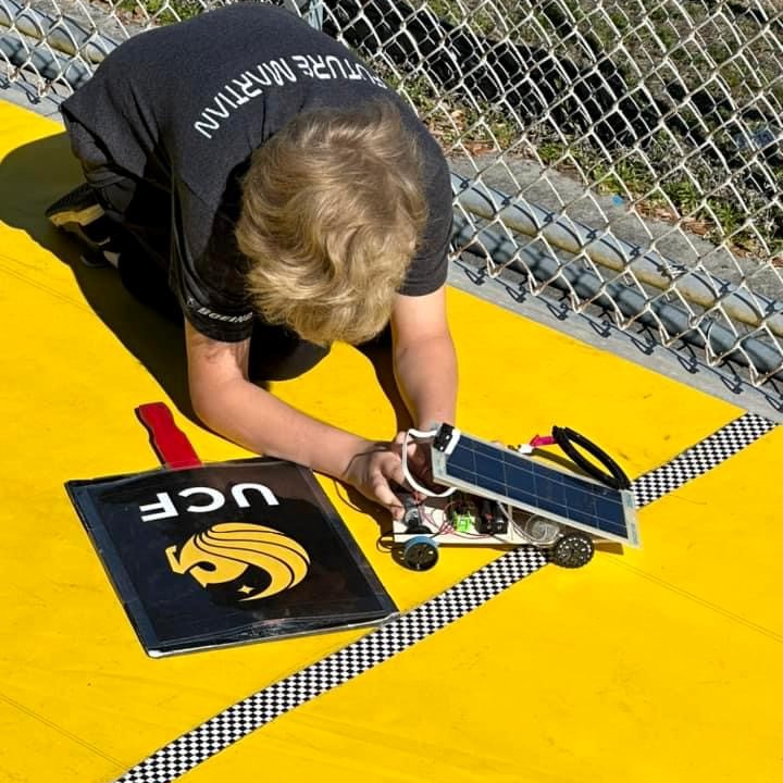 student working on a solar car