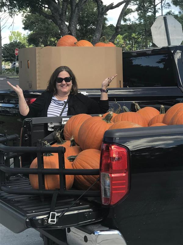 girl at the back of a truck full of pumpkins