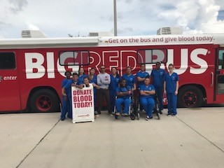 people standing in front of a bus holding a sign 