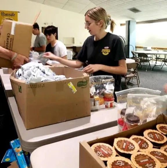 Teen girl helping to pack meal bags
