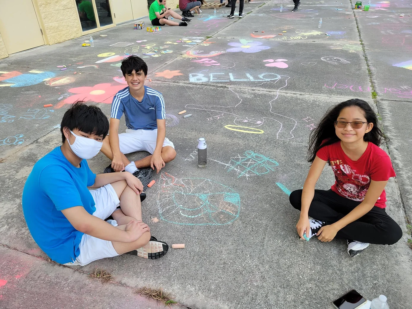 Group of kids drawing with chalk on the floor