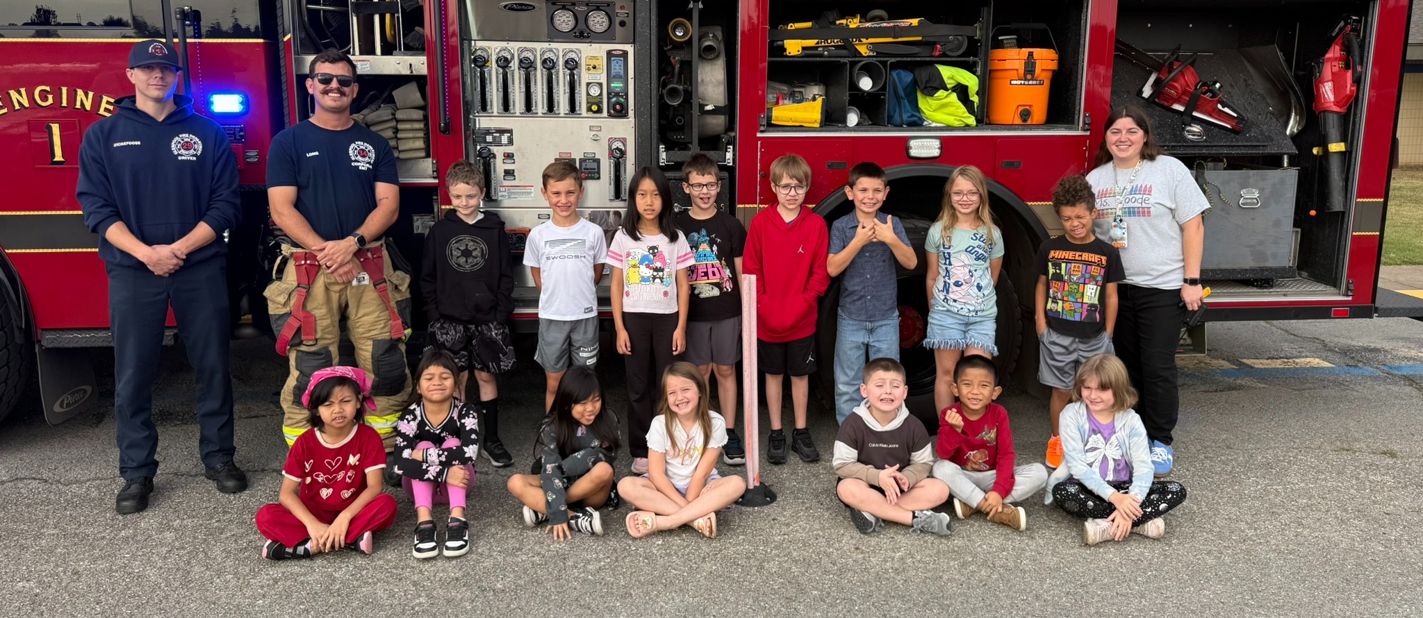 Students sitting in front of a fire engine