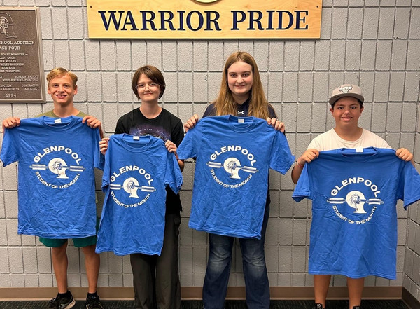 students holding student of the month shirt