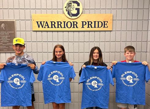 students holding student of the month shirt