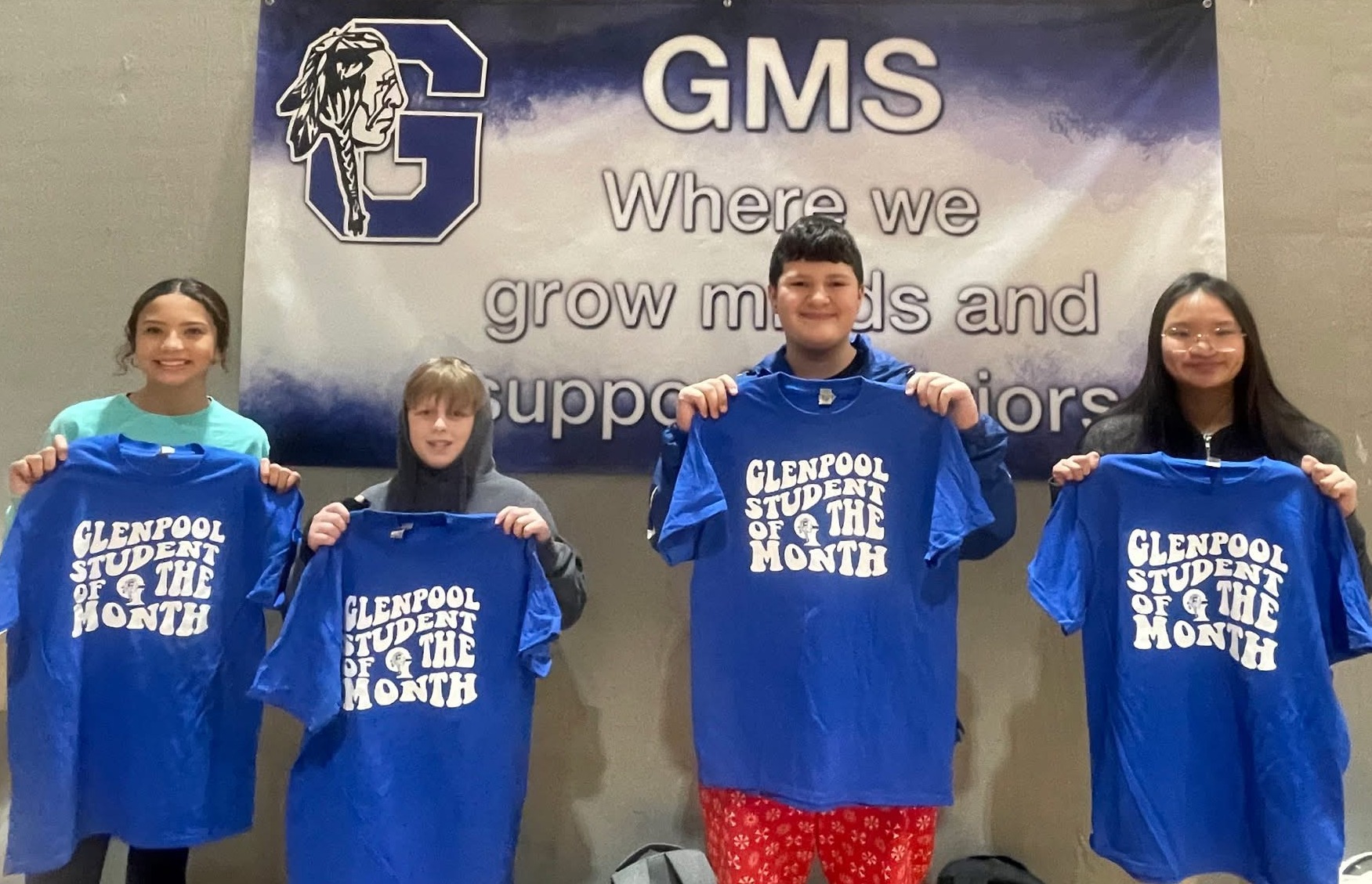 students holding student of the month shirt