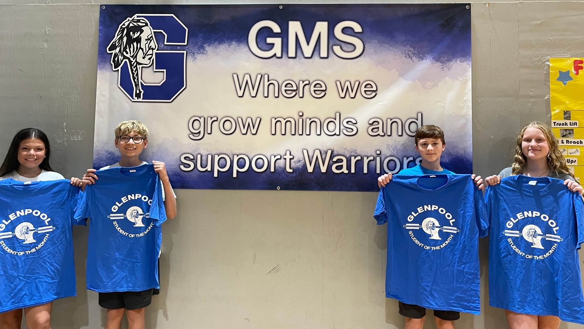 students holding student of the month shirt