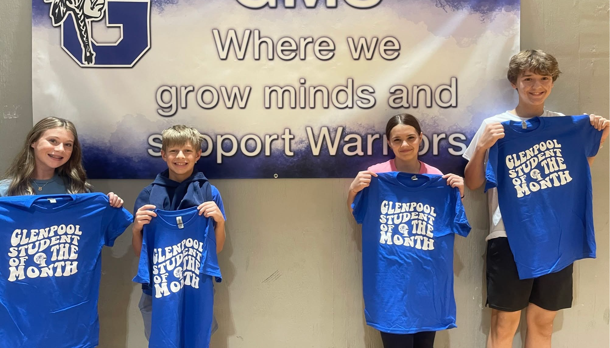 students holding student of the month shirt