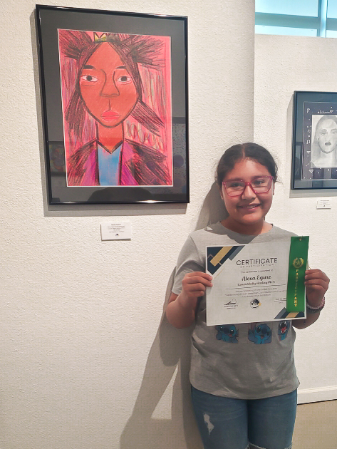 girl holding a diploma standing in front of a wall