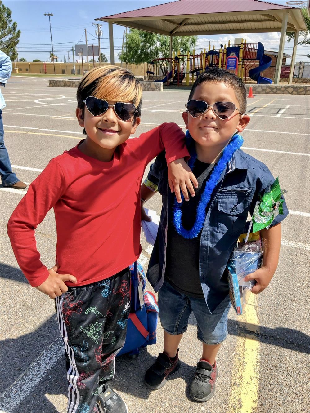 two boys wearing sunglasses smiling