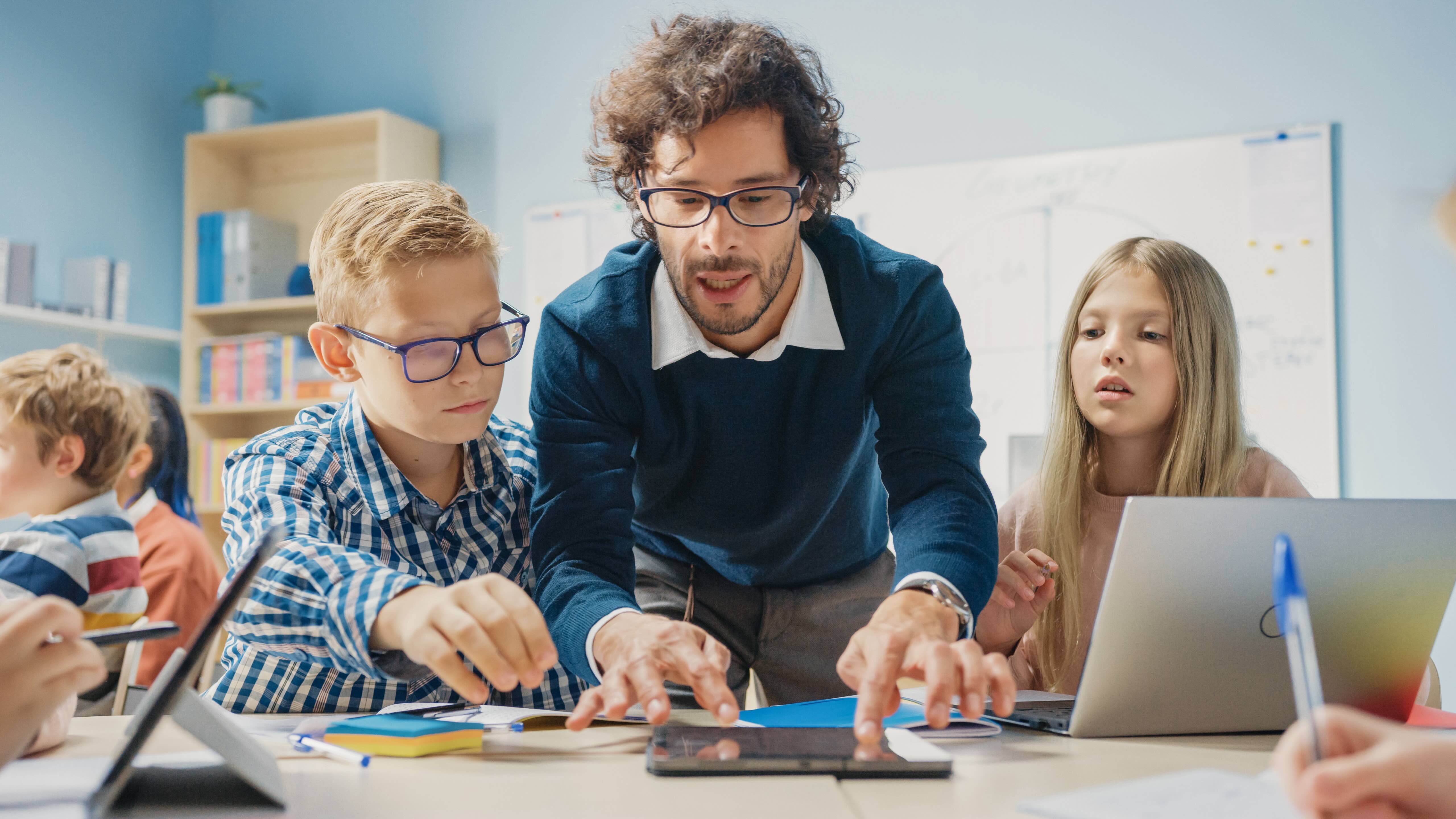 Teacher Using Technology With Students Image