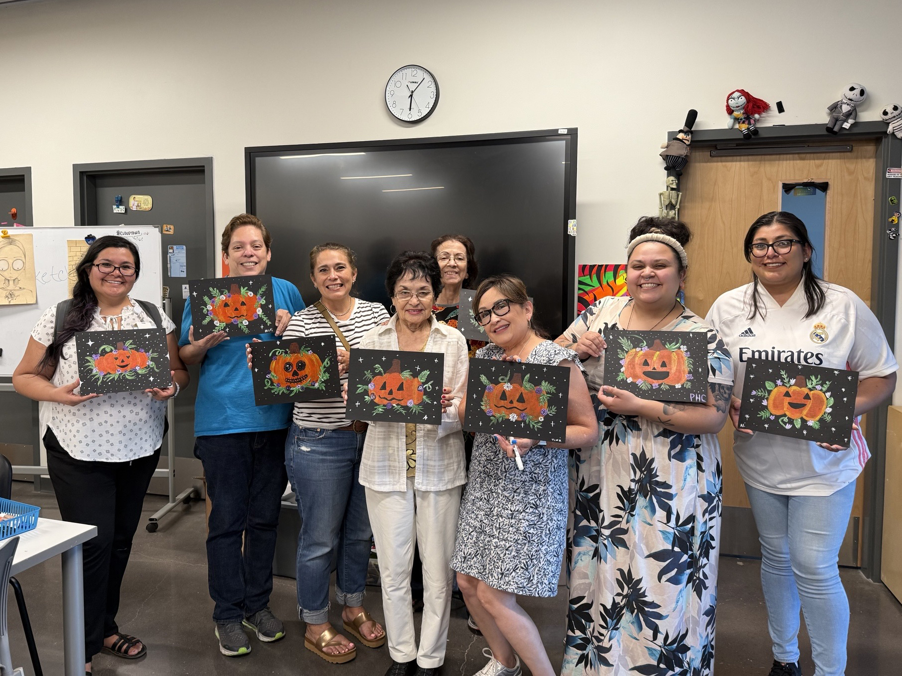 Employees posing with pumpkin artwork