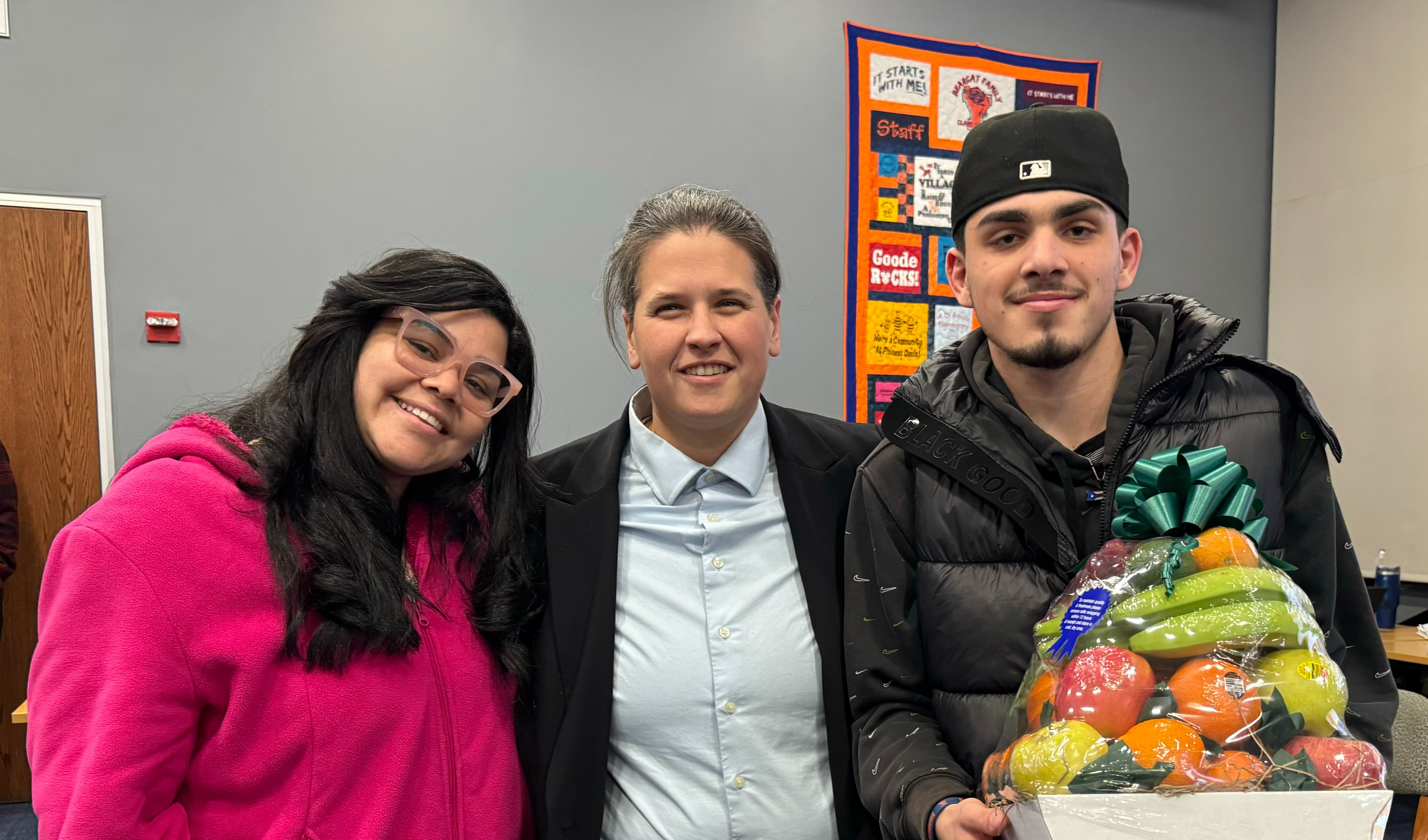 Bearcat Cyber Academy Principal Leah Hillard presenting a family from Bearcat Cyber Academy with the Celebrating Families Award during a School Board Meeting.