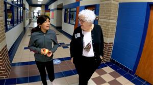 2 women walking in a school hall