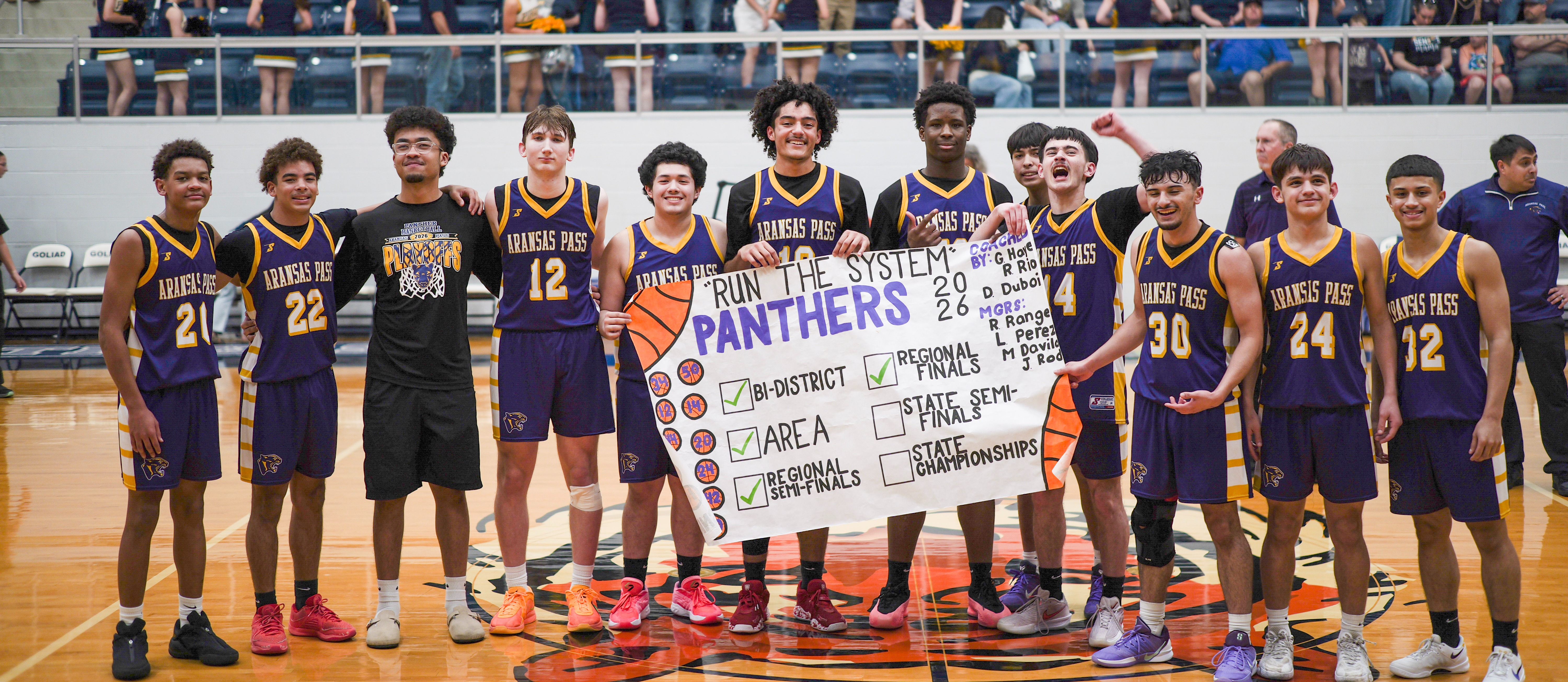 Boys Basketball team holding a banner after winning Regional Finals Game